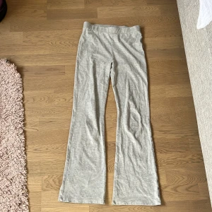 Grå byxor från Kappahl - Säljer ett par grå byxor från Kappahl. De har en bekväm passform med elastisk midja och är tillverkade i ett mjukt material. Perfekta för en avslappnad stil.