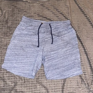 Grå shorts med snörning - Snygga grå shorts med en avslappnad passform och praktisk snörning i midjan. 