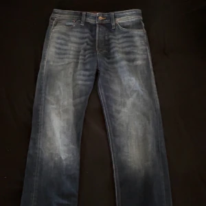 Blå jeans från Jack & Jones - Snygga blå jeans från Jack & Jones med en klassisk femficksdesign. De har en lätt tvättad look och en knappgylf. Perfekta för en avslappnad stil.