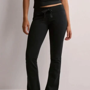 Svarta mjukisbyxor med knytband - Snygga svarta mjukisbyxor med knytband i midjan. Byxorna har en bekväm passform och är perfekta för en avslappnad stil. De är tillverkade i ett mjukt material som ger en skön känsla hela dagen.