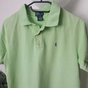 Grön pikétröja från Ralph Lauren - Säljer två snygga pikétröjor från Ralph Lauren med klassisk krage och knappar framtill. Perfekt för en stilren look. En grön och en vit  💚 800kr för båda. Ps storleken finns i bilden