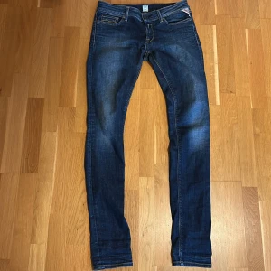 Blå jeans från Replay - Snygga blå jeans från Replay med klassisk femficksdesign och snygga sömdetaljer på bakfickorna💯. Jeansen har en knappgylf och är i en stilren blå tvätt som passar perfekt till vardags eller finare tillställningar👍 jeansen är i väldigt bra skick med minimala tecken på användning som t.ex strecken i knävecken✅ skriv till mig vid frågor och funderingar så försöker jag svara så snabbt jag kan😊