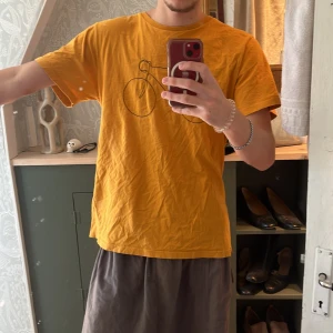 Gul t-shirt med cykeltryck från Dedicated - Säljer en gul t-shirt från Dedicated med ett stilrent cykeltryck på framsidan. Gjord av 100% ekologisk och Fairtrade-certifierad bomull. Perfekt för dig som gillar en avslappnad stil med en touch av personlighet. 🌟