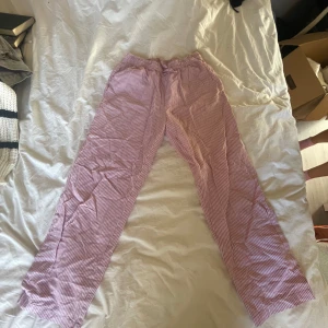 Randiga pyjamas byxor i rosa och vit - Säljer ett par bekväma pyjamasbyxor med rosa och vita ränder. 