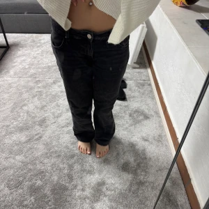 Svarta jeans från Zara - Snygga svarta jeans från Zara med en klassisk design. De har en rak passform och är perfekta för en avslappnad stil. Jeansen har en knapp och dragkedja framtill. även låg midja det