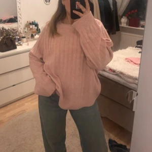 Rosa stickad tröja - Mysig rosa stickad tröja med ribbad design. Perfekt för kyligare dagar med sin avslappnade passform och långa ärmar. Enkelt att matcha med jeans eller kjol för en bekväm look.  Från lager 157 storlek M. Aldrig använd