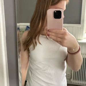 Vit ribbad linnetopp - Säljer en stilren vit ribbad linnetopp. Ärmlösa design och mjukt material. Passar till allt.