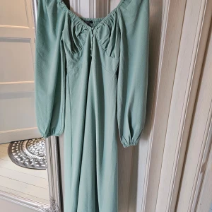 Grön långklänning från Gina Tricot - Helt ny! Med slits i mitten och ballongärmar. Den ser blågrön ut i vissa ljus men den är grön (som bild 2, 3, 4) , normal i storlek, dock lite för liten för mig som är mellan S & M, därför säljer jag. Välj gärna instabox om möjligt 😊 