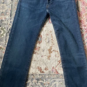 Levis 501 Original Jeans - Ny oanvänd!! Klassiska Levis 501 Original jeans i en snygg mörkblå färg. Dessa jeans har en rak passform och är tillverkade i stretchigt denim för extra komfort. Perfekta för en avslappnad stil. Storleken är 30/32