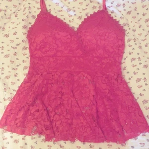 Rött spetslinne - Supersött rött linne med spets och volang nertill. V-ringad med smala axelband. Perfekt för dig som gillar romantiska detaljer och vill sticka ut lite extra. Den ser mer rosa ut på bilden men i verkligheten är den röd. Köpt på marknaden så finns inget speciellt märke eller storlek men skulle säga att den är i xs/s. ❤️Köpte den för 180 kr och använt få gånger, därför säljer jag den för 100 kr! 