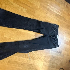 Svarta bootcut jeans 157 S - Svarta jeans från 157 i bootcut-modell med råa, fransiga benslut. Klassisk femficksdesign och dragkedja fram. Jeansen har en snygg, mörk tvätt och är tillverkade i mjukt denimtyg. Perfekta för dig som gillar en avslappnad men trendig look. Dom är lite slitna längst nere men inget som man tänker på