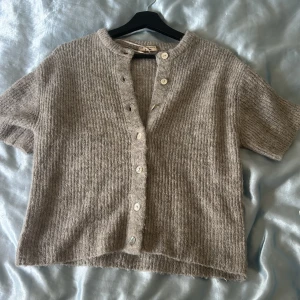 Beige stickad kofta med kort ärm - En jätte mysig kofta från Gina den är lite ljusare i verkligheten än på bilderna ba så ni vet var använts ett fåtal gånger💗