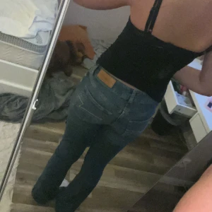 Blå bootcut jeans från Junkyard S - Säljer ett par blå bootcut jeans från Junkyard i storlek S. Jeansen har klassisk femficksdesign, snygga kontrastsömmar och låg midja. Materialet är jeans med en skön passform och coola detaljer på bakfickorna. Perfekta för dig som gillar en tidlös och trendig look. Jag är ca 170 och dom är lite för långa på mig 💗💗