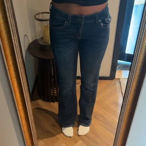 Mörkblå bootcut jeans med fickdetaljer - Snygga mörkblå jeans med bootcut, lågmidjade. Fickdetaljer med knapp bak. Gina young, storlek 170 