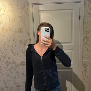 Mörkblå velour hoodie med dragkedja - Mysig mörkblå hoodie i velour med huva och dragkedja framtill. Jackan har långa ärmar, snörning i huvan och två fickor fram. Perfekt för chill dagar eller när du vill vara extra comfy.