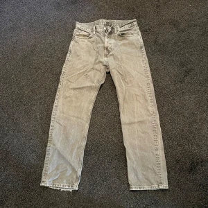 Grå raka jeans från Weekday 29/30 - Säljer ett par grå jeans från Weekday i modellen Space Relaxed Straight. Jeansen har rak passform, klassisk femficksdesign och är tillverkade i bomull. Perfekta för dig som gillar en avslappnad och stilren look. De har ett litet slitage på vänstra bakfickan syns på andra bilden.