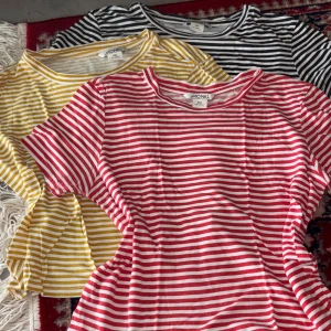 Randiga t-shirts från Monki XXS - Tre randiga t-shirts från Monki i storlek XXS. En i rött och vitt, en i gult och vitt samt en i svart och vitt. Alla har kort ärm, rund hals och är gjorda i mjuk bomull. 