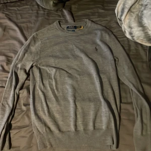 Grå tröja Polo Ralph Lauren XS - Snygg grå långärmad tröja från Polo Ralph Lauren i slim fit-modell. Klassisk rund halsringning och diskret broderad logga på bröstet. Perfekt för dig som gillar stilrena och enkla plagg med premiumkänsla. Inga defekter väldigt skön