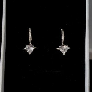 Örhängen  - Ett par snygga örhängen i silverfärg med gnistrande hjärtformad sten och små stenar på själva ringen. Hängande modell som ger en cool och elegant vibe. Perfekta för att lyfta din look med lite extra bling.
