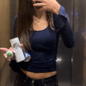 Mörkblå soft touch tröja från Gina tricot  - Snygg mörkblå croppad tröja med lång ärm och rund halsringning. Perfekt för dig som gillar en enkel men stilren look. Tröjan sitter tight och har en basic design som passar till det mesta. Skön att bära och lätt att matcha med jeans eller kjol.