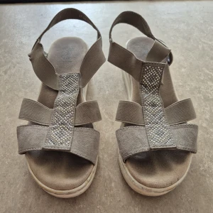 Sandaler - Snygga beige sandaler från So All med platåsula och breda remmar i mocka och textil. Dekorerade med glittrande stenar i mönster på ovansidan. Perfekta för sommarens alla outfits och ger extra höjd med sin plattform.