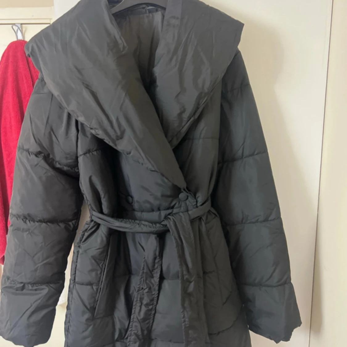 Svart pufferjacka med bälte