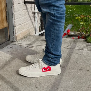 Converse Play x Comme des Garçons vita sneakers - Säljer ett par feta vita Converse Play x Comme des Garçons sneakers med den ikoniska röda hjärtloggan på sidan.  Perfekta för dig som vill ha en stilren men unik sneaker. Använt dem en gång då de va för stora