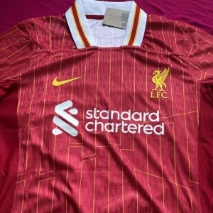 LIVERPOOL HEMMATRÖJA 24/25 - Säljer denna snygga liverpool hemma tröjan i storlek M för 24/25 säsongen med ALEXANDER  TRENT ARNOLD på ryggen. tröjan är helt ny och oanvänd med tagg. Pris kan diskuteras skriv gärna vid funderingar eller för mer bilder. Postar samma dag vid köp