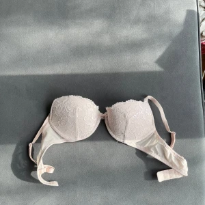Ljusrosa spets-bh Lindex - Fortfarande väldigt Fräsch!!!Säljer en ljusrosa bh med spetsdetaljer och vadderade kupor. Bh:n har justerbara axelband och en klassisk knäppning bak. Perfekt för dig som vill ha en feminin och stilren underklädeslook.