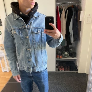 Klassisk blå jeansjacka  - Säljer en klassisk blå jeansjacka från H&M. Jackan har knappar framtill, två bröstfickor med lock och knapp samt två sidofickor. Perfekt till lager-på-lager och funkar året runt. Snygg och tidlös modell med normal passform.