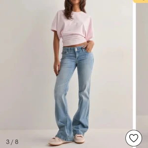 Ljusblå bootcut jeans med broderade bakfickor - Snygga ljusblå jeans med bootcut passform och broderade detaljer på bakfickorna. Jeansen har normal passning och klassisk femficksdesign. Perfekta för en avslappnad och trendig look.