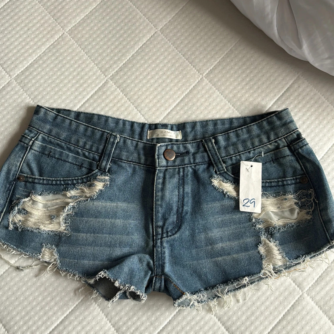 Blå jeansshorts med fransar och slitningar
