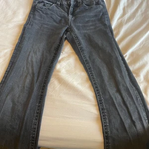 Svarta jeansbyxor från Gina Tricot - Snygga svarta jeansbyxor från Gina Tricot i bootcut modell. Byxorna har fem fickor och silverfärgade knappar. Perfekta till många olika outfits och enkla att matcha! Passar som XS och om du är 160 cm!