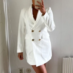 Vit kavajklänning med guldknappar - Oanvänd med prislapp kvar. Några fläckar som syns på bild, går bort i tvätten.