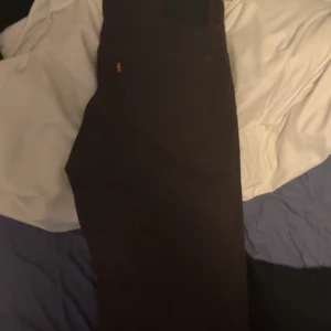 Bruna jeansbyxor från Levi's - Säljer ett par bruna jeansbyxor från Levi's med klassisk femficksdesign och dragkedja. Byxorna har rak passform och normal midja. Perfekta till vardags och passar till det mesta.