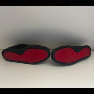 Christian Louboutin skor - Säljer ett par svarta Christian Louboutin med en klassisk design och snygg röd sula undertill. Skorna har snörning och rund tå, tillverkade i skinn. Perfekta för dig som gillar stilrena skor, innersulan saknas tyvärr och hälen innuti är skadad, men inget man tänker på. Skorna har blivit lite slitna på tån. Hälen är även lite sliten🏆Skorna kan komma ny tvättade vid önskan🏆 (Inget og finns) skriv vid andra frågor eller vid intresse, kom gärna med bud 