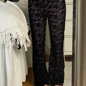 Spetsbyxor  - Säljer ett par svarta spetsbyxor med lila/rosa tyg insytt, köptes här på plick. Dragkedjan är fast, bild 2, men det har inte stört mig. Uppskattar till storlek M.