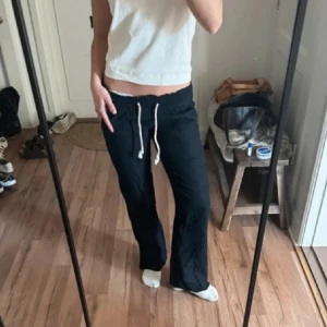 Mörkblå linnebyxor  - Mörkblå linnebyxor från Roxy med avslappnad passform och vit snörning i midjan. Byxorna har raka ben perfekta för en chill och stilren look. Använda ett fåtal gånger