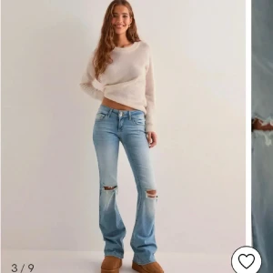 Ljusblå bootcut jeans med slitningar - Dessa hellt slutsålda jeans fårn Nelly, vet inte om dom säljs i denna passform längre. Jag har använde de några gånger och de är för långa därav lite slitningar längst ner men inget som andra tänker på alls. Jag undrar om någon har dom i 32 och vill byta eller om någon vill köpa så skriv till mig. Dom är jätte fina, populära och lågmidjade. Köpte dom för 700.