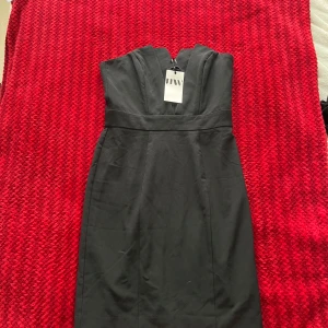 Svart axelbandslös klänning  - Säljer en svart axelbandslös klänning med markerad midja. Klänningen har en elegant och stilren design som passar perfekt till speciella tillfällen. Materialet känns slätt och exklusivt. 💕