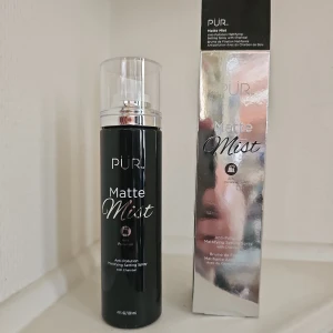 PÜR Matte Mist Anti-pollution Setting Spray - Ord pris 395kr. Mattande face mist från PÜR med kol, perfekt för att fixera sminket och ge en matt finish. Kommer i svart flaska med genomskinligt lock och silvrig förpackning. Enkel att använda med spraypump.