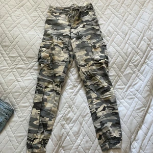 Camouflage cargobyxor  - Använda, ena knappen på fickan är trasig 
