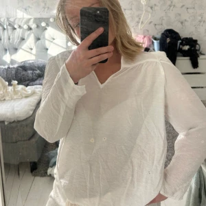 Vit blus från Kappahl - Säljer en luftig och stilren vit blus från Kappahl med v-ringning och långa ärmar. Perfekt till både jeans och kjol. Blusen har en avslappnad passform och är gjord i ett tunt, skönt material. 