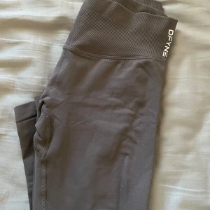 Grå seamless tights från DFYNE - Säljer ett par grå seamless tights från DFYNE. Tightsen har en tight passform och är perfekta för träning. Säljes då de sitter för tajt på mig 🫶