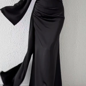 Elegant långklänning med vida ärmar - Säljer en elegant långklänning i satin med markerad midja och vida långa ärmar. Klänningen har draperade detaljer och finns i både svart och blå. Perfekt för bal eller festliga tillfällen. Pris är 1000kr för varje en. Vi kan diskutera priset 