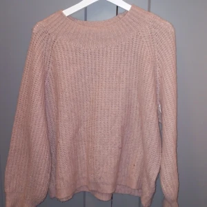 Råsa stickad tröja - Mysig råsa stickad tröja med långärmad design och bred ribbad krage. Perfekt för kyligare dagar och enkel att matcha med olika outfits.