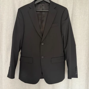Svart kostym från Dressmann - Svart kostym ifrån Dressman. Kavajen är i storlek 44-short och byxorna i storlek 30/30. Nypris ca 4000
