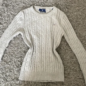 Ljusgrå stickad tröja från Gant - Säljer en ljusgrå stickad tröja från Gant i stretchig bomull. Den är i storlek XS. Tröjan har rund halsringning, lång ärm och diskret broderad logga på bröstet. Perfekt för en stilren och klassisk look. Den är använd fåtal gånger och ser nästan ut som ny!🩷