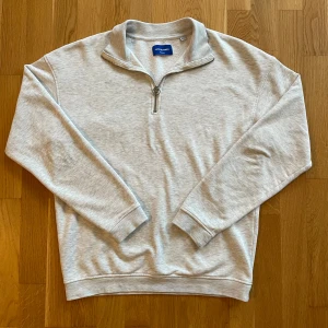 Ljusgrå halvzip från Jack & Jones - Säljer en ljusgrå sweatshirt med halvzip från Jack & Jones. Passar bra till många outfits 