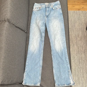 Ljusblå jeansbyxor med slits från 157 - Säljer ett par ljusblå jeansbyxor från 157 med raka ben och slits nertill. Klassisk femficksmodell med knapp och dragkedja framtill. Perfekta för dig som gillar en avslappnad stil.